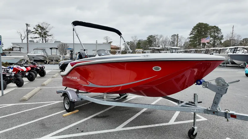 Slide: The Image of 2025 Bayliner M15 boat in vibrant red on a trailer, parked outdoors. - 5