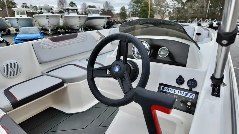 Slide: The Image of 2025 Bayliner M15 boat interior with steering wheel and seating, displayed outdoors. - 6