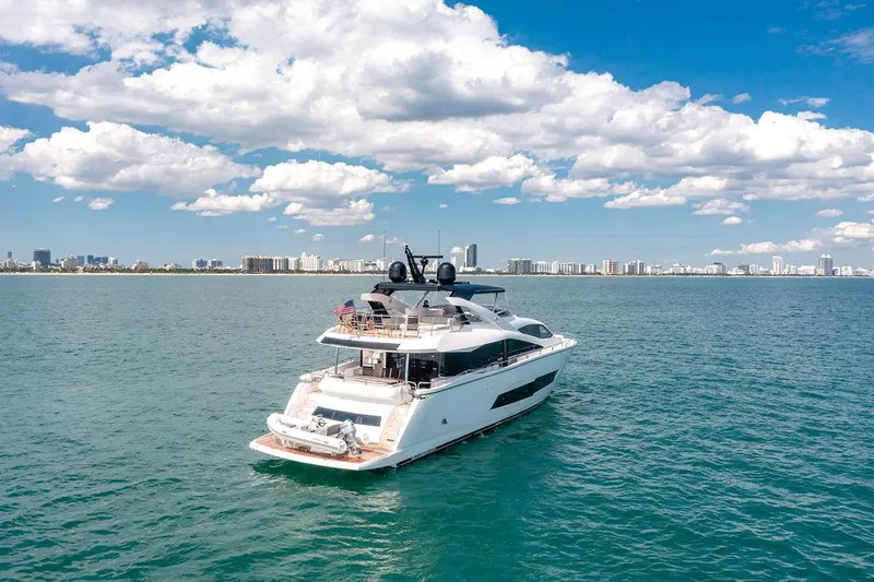 Slide: The Image of Sunseeker 86 Yacht 2021 cruising on open water with city skyline in background. - 11