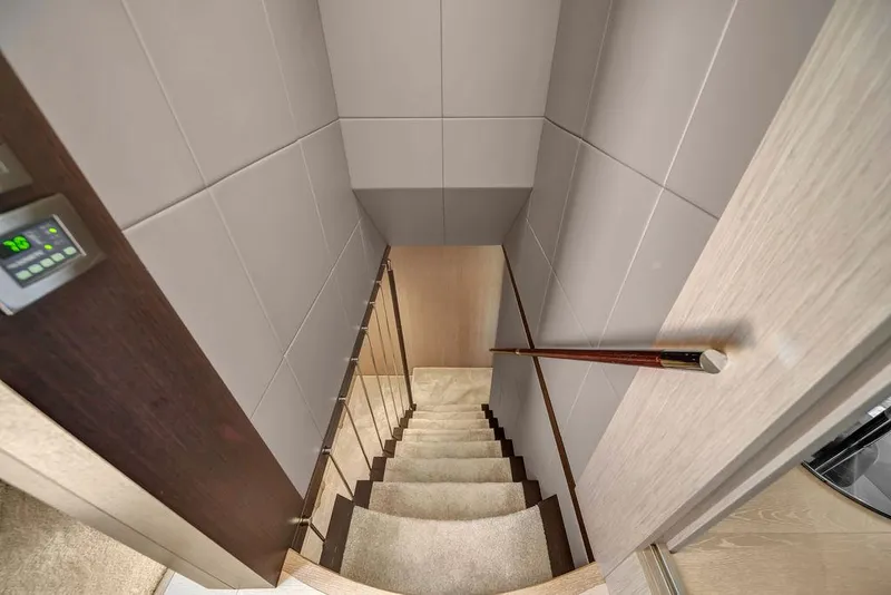 Slide: The Image of Interior staircase of 2021 Sunseeker 86 Yacht, featuring modern design and wood accents. - 29