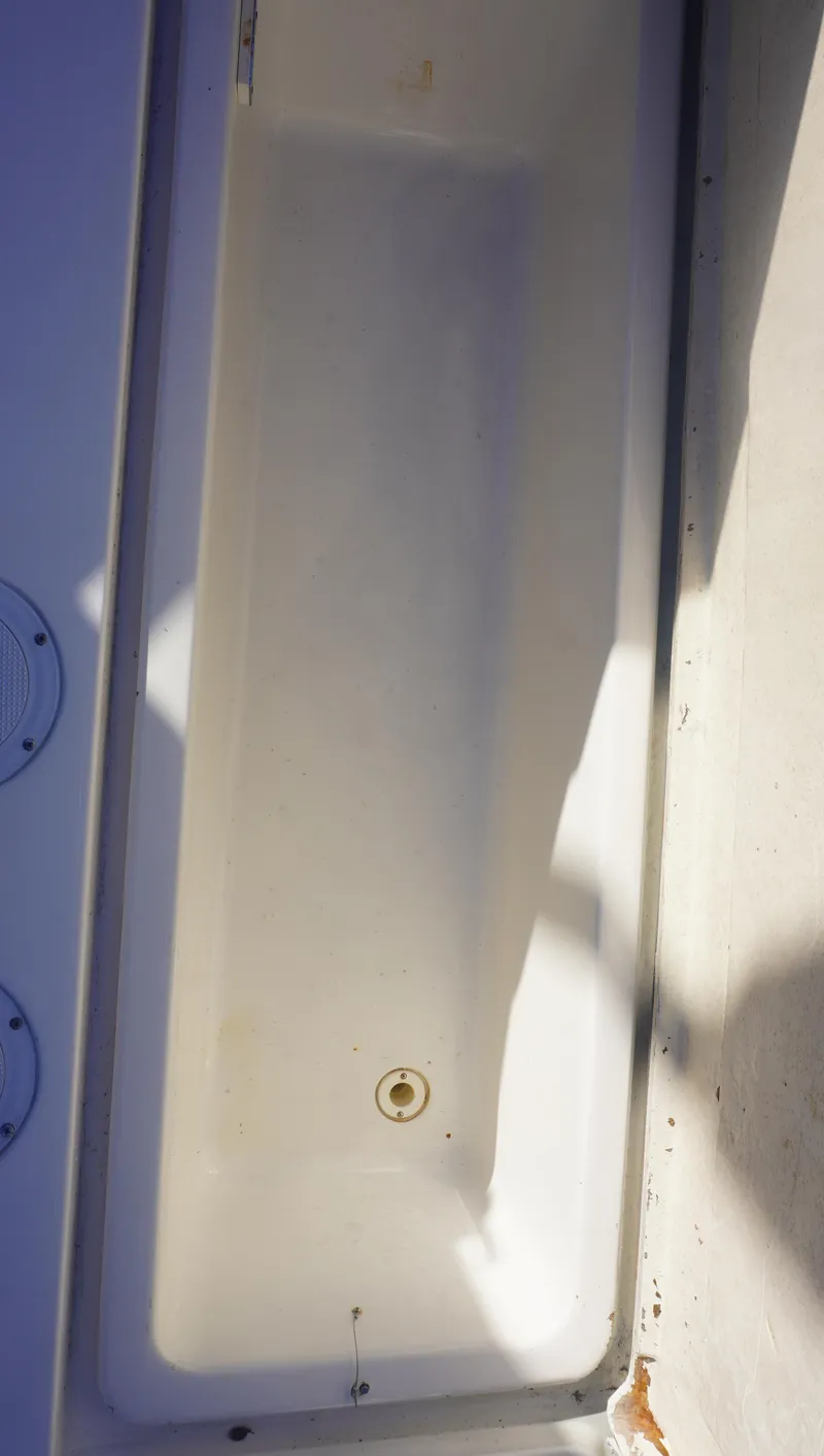 Slide: The Image of 2002 Sea Ray 340 Amberjack boat storage compartment, white interior, shadowed lighting. - 10