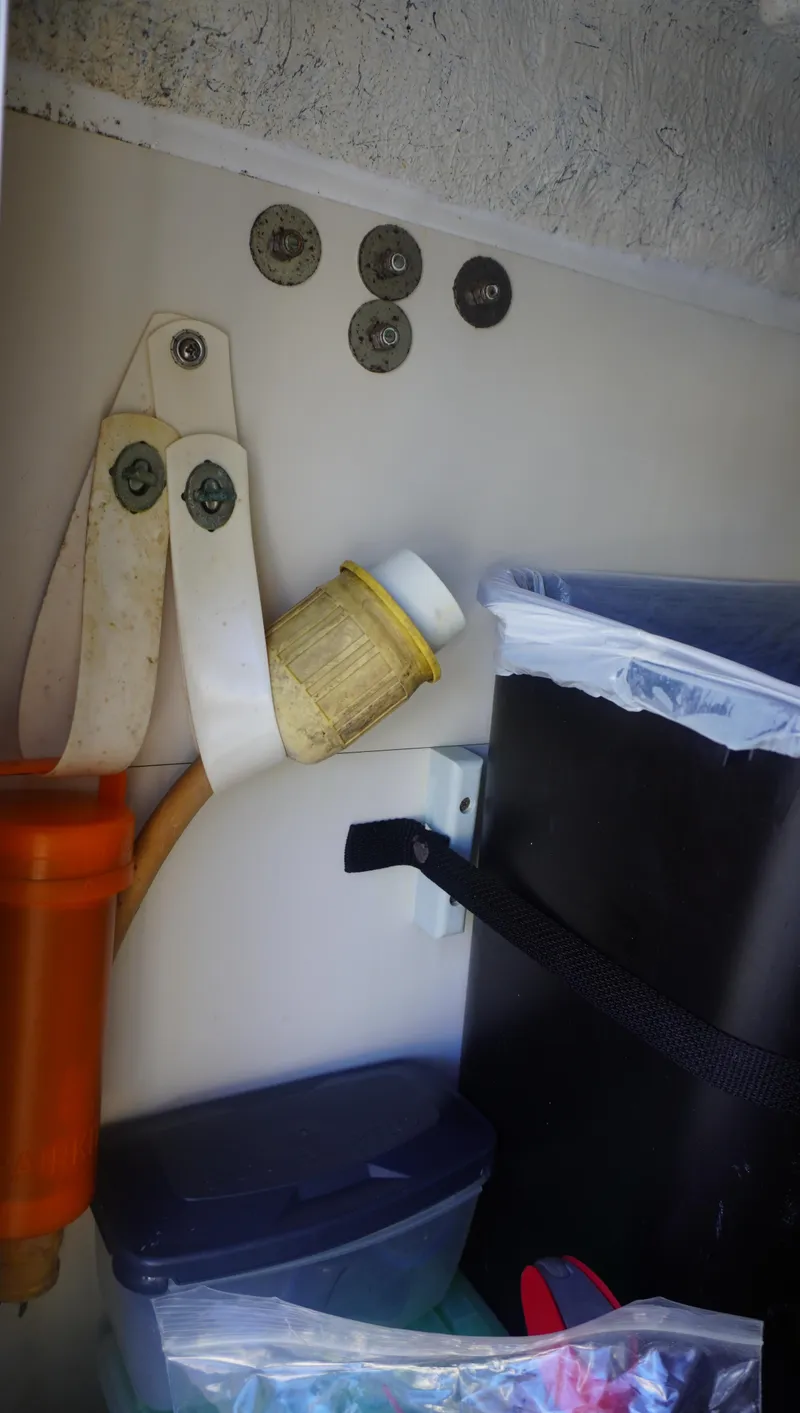 Slide: The Image of Storage area on a 2002 Sea Ray 340 Amberjack boat with various items and coins. - 17