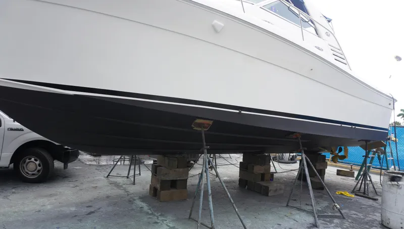 Slide: The Image of Sea Ray 340 Amberjack 2002 on dry dock, supported by stands and blocks. - 2