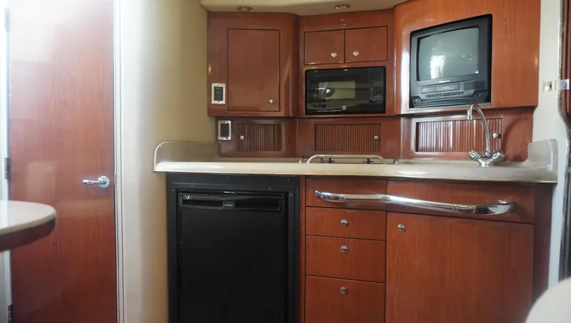 Slide: The Image of 2002 Sea Ray 340 Amberjack cabin kitchen with wood cabinetry and modern appliances. - 32