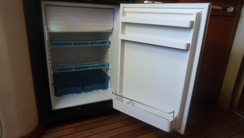 Slide: The Image of Open refrigerator inside 2002 Sea Ray 340 Amberjack boat, showing shelves and storage compartments. - 38