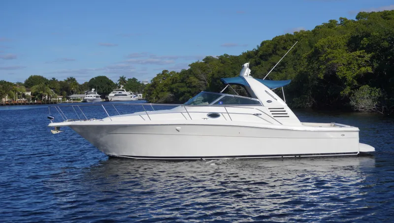Slide: The Image of 2002 Sea Ray 340 Amberjack boat cruising on a serene river with lush greenery. - 49