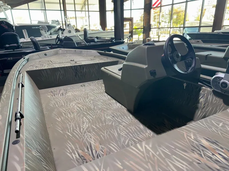 Slide: The Image of 2024 Tracker Grizzly 1648 SC boat interior with camouflage design in showroom. - 6
