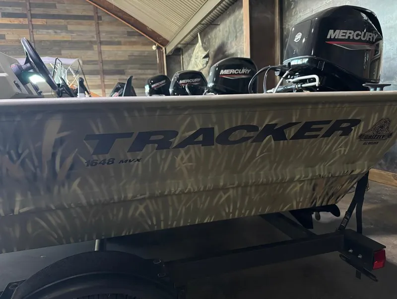 Slide: The Image of 2024 Tracker 1648 SC boat with Mercury outboard motor in a garage. - 4