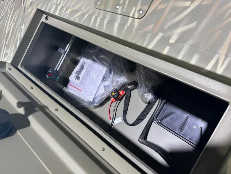 Slide: The Image of 2024 Tracker 1648 SC storage compartment with tools and wiring. - 9