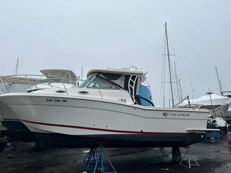 The Image of 2017 Striper 270 Walkaround boat on stands in a marina setting. - 0