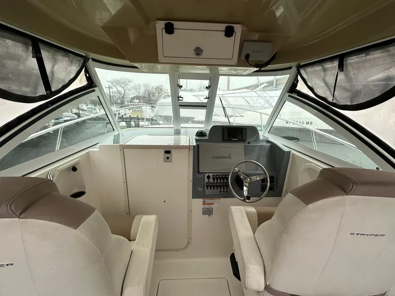 Slide: The Image of 2017 Striper 270 Walkaround boat interior with helm, steering wheel, and seating. - 10