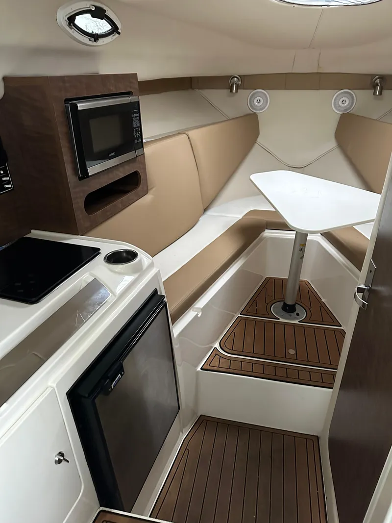 Slide: The Image of 2017 Striper 270 Walkaround cabin with kitchenette, seating, and table. - 9