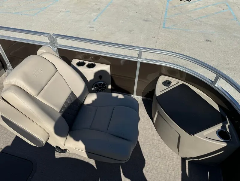 Slide: The Image of 2025 Sun Tracker 24 Sportfish XP3 boat interior with beige seating and cup holders. - 12