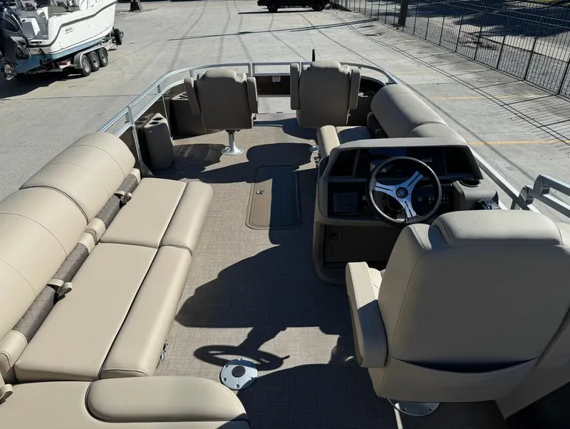 Slide: The Image of 2025 Sun Tracker 24 Sportfish XP3 pontoon boat interior with beige seating and steering console. - 19