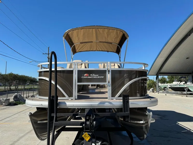 Slide: The Image of 2025 Sun Tracker 24 Sportfish XP3 pontoon boat with canopy, parked outdoors. - 4