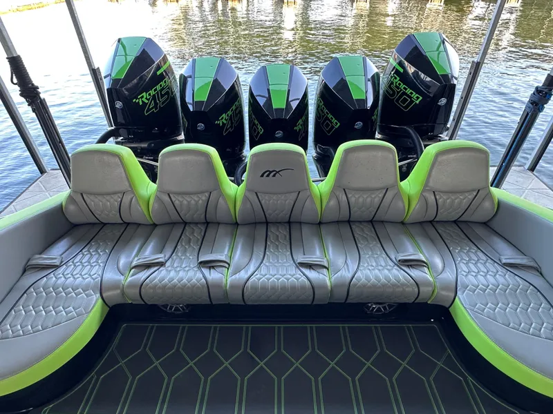 Slide: The Image of 2022 Midnight Express 43 Solstice boat with green-accented seating and powerful outboard engines. - 10