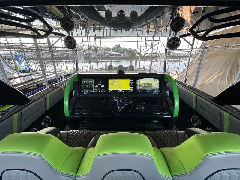 Slide: The Image of Interior of 2022 Midnight Express 43 Solstice boat with modern dashboard and green accents. - 13