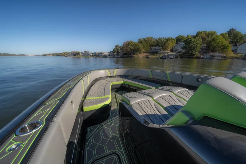 Slide: The Image of 2022 Midnight Express 43 Solstice boat on a serene lake with lush shoreline. - 23