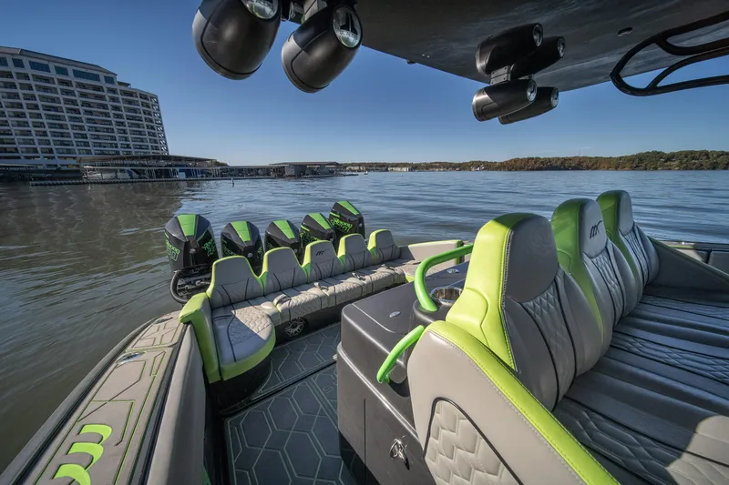Slide: The Image of 2022 Midnight Express 43 Solstice boat interior with green accents on a calm lake. - 28