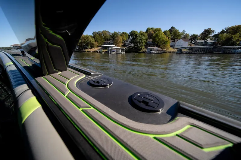 Slide: The Image of 2022 Midnight Express 43 Solstice boat on a serene lake with scenic shoreline. - 37