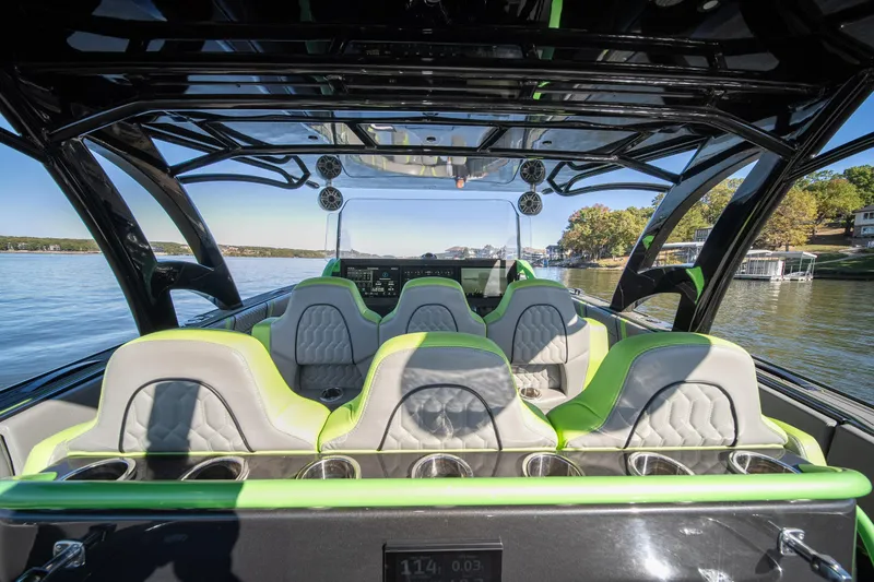 Slide: The Image of Interior of 2022 Midnight Express 43 Solstice boat with green-accented seats on a sunny day. - 43