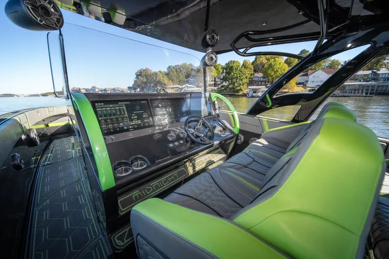 Slide: The Image of Interior of 2022 Midnight Express 43 Solstice boat with modern dashboard and green seating. - 45