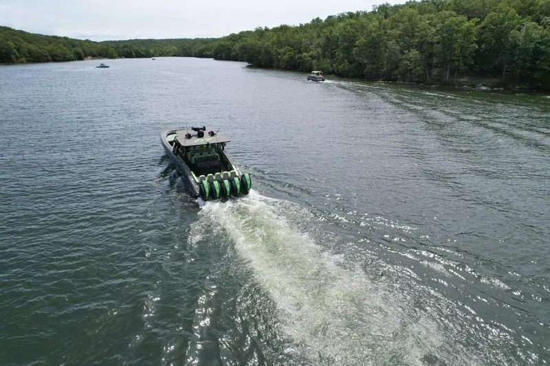 Slide: The Image of 2022 Midnight Express 43 Solstice cruising on a scenic river with lush green surroundings. - 6