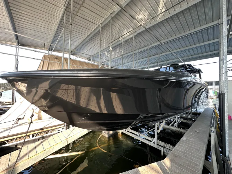 Slide: The Image of 2022 Midnight Express 43 Solstice boat docked under a metal canopy. - 9