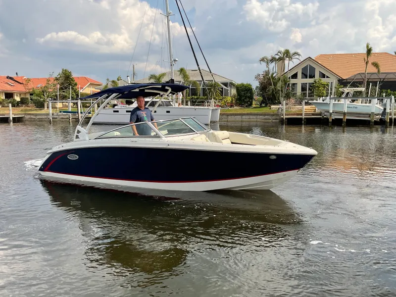 Slide: The Image of 2016 Cobalt R5 boat cruising on a calm waterway near waterfront homes. - 4