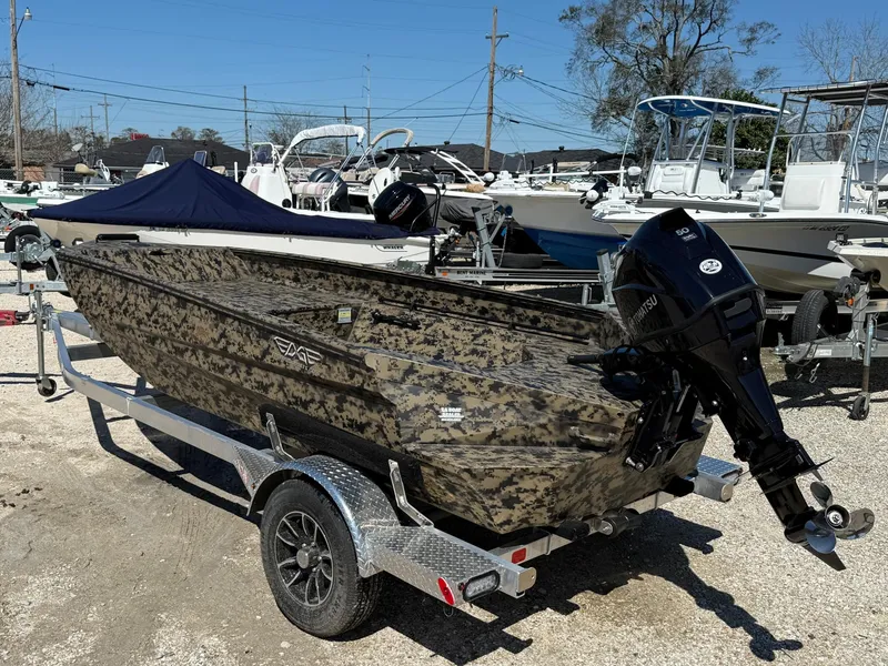 Slide: The Image of 2025 Edge Duck Boats 656DB on trailer, camo design, outboard motor, parked in marina. - 4