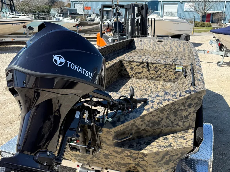 Slide: The Image of 2025 Edge Duck Boats 656DB with Tohatsu engine, camo design, in a boatyard. - 5