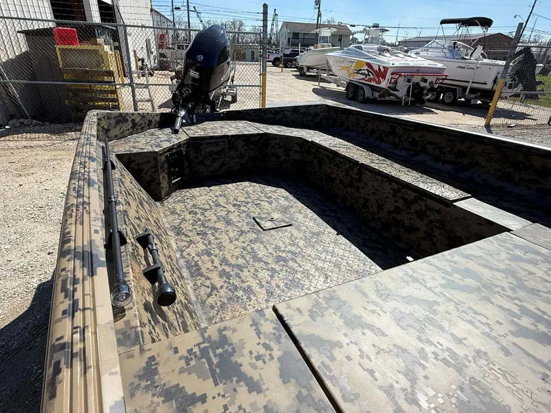 Slide: The Image of 2025 Edge Duck Boats 656DB with camouflage design, parked outdoors near other boats. - 7