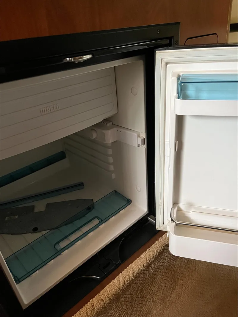 Slide: The Image of Open mini fridge inside 2008 Rinker 260 Express Cruiser boat cabin. - 10