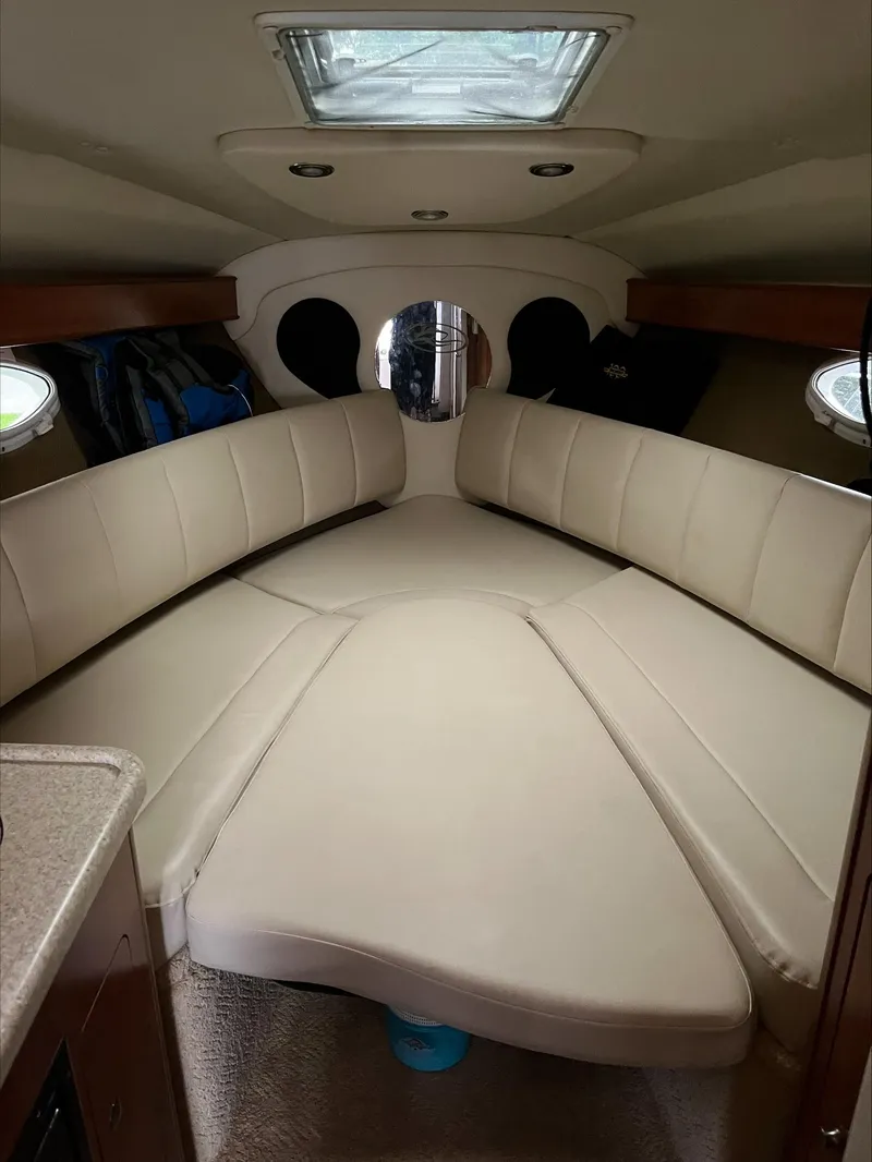 Slide: The Image of 2008 Rinker 260 Express Cruiser cabin with beige seating and overhead skylight. - 13