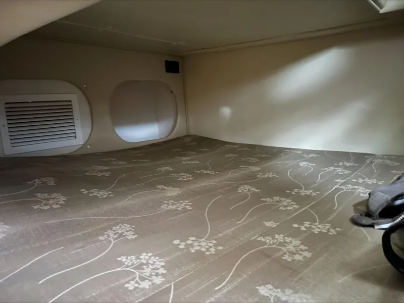 Slide: The Image of 2008 Rinker 260 Express Cruiser cabin interior with floral-patterned bedding. - 16
