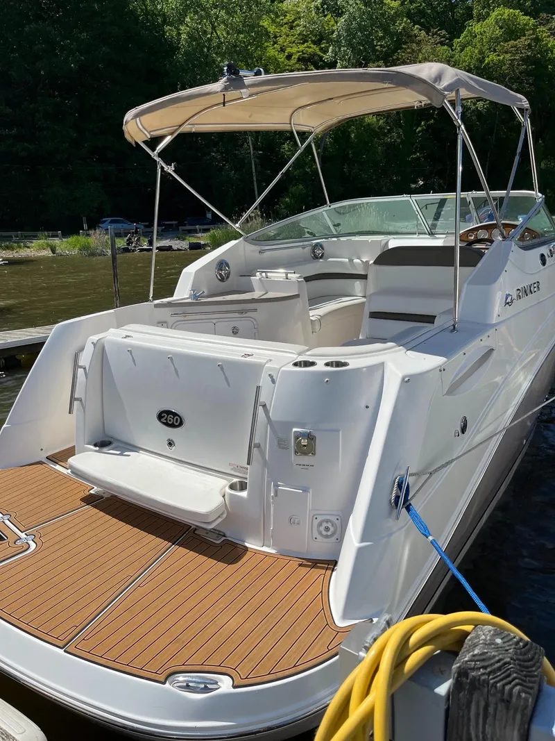 Slide: The Image of 2008 Rinker 260 Express Cruiser docked, featuring spacious deck and canopy. - 2
