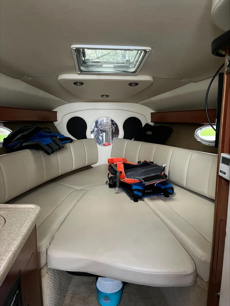 Slide: The Image of Interior of 2008 Rinker 260 Express Cruiser with beige seating and life jackets. - 6