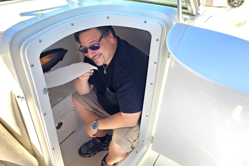 Slide: The Image of Man sitting inside 2016 Hurricane SD2200 O/B boat compartment, smiling with sunglasses. - 14