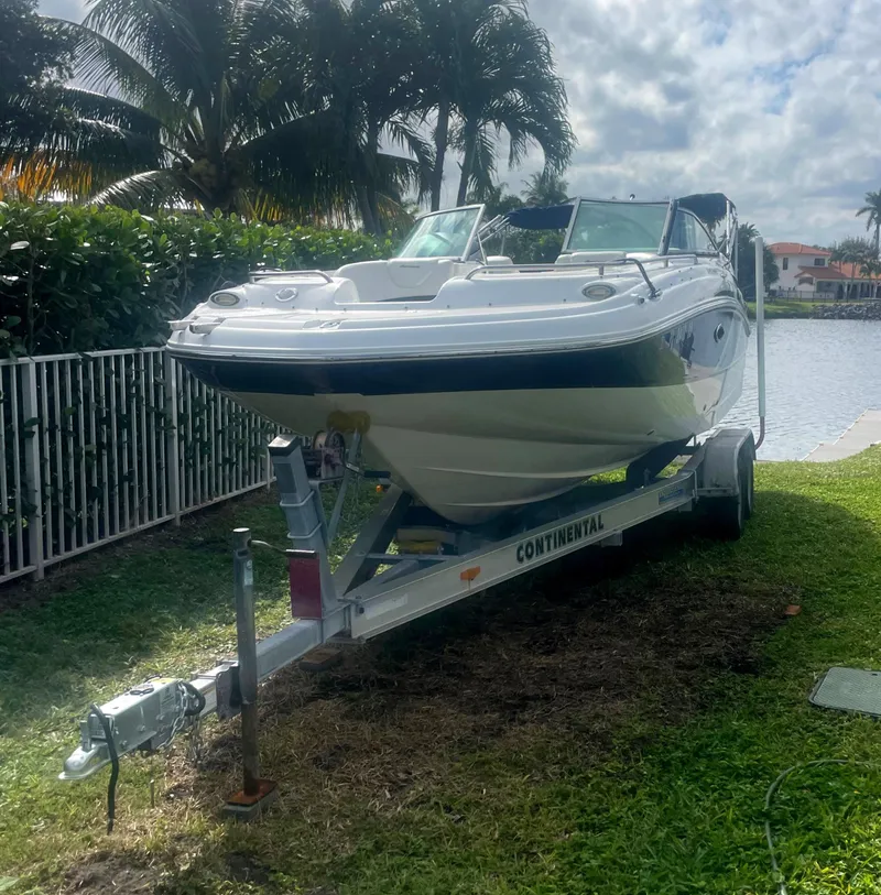 Slide: The Image of 2016 Hurricane SD2200 O/B boat on trailer by waterfront, surrounded by palm trees. - 3