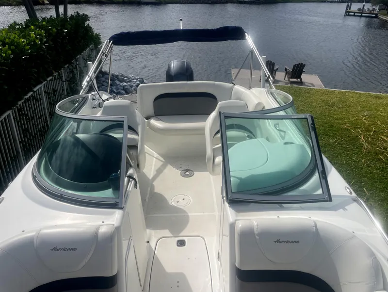 Slide: The Image of 2016 Hurricane SD2200 O/B boat with open deck, docked by a serene waterfront. - 6