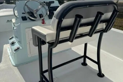 Slide: The Image of 2024 Action Craft 22 Coastal Bay boat interior with steering console and cushioned seating. - 22