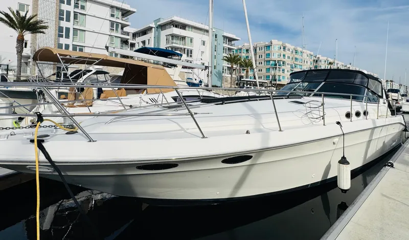 Slide: The Image of 1994 Sea Ray 400 Express Cruiser docked at marina with modern buildings. - 0