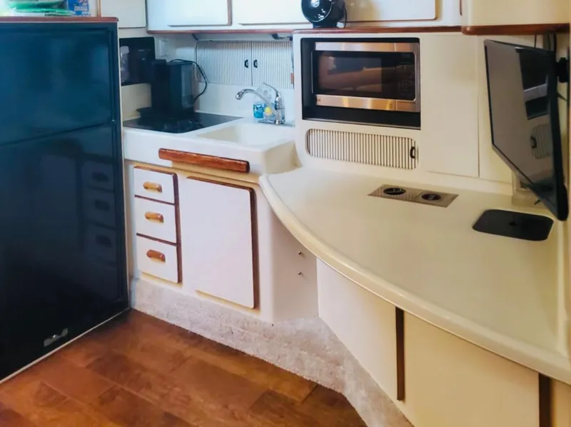 Slide: The Image of 1994 Sea Ray 400 Express Cruiser kitchen with modern appliances and wood flooring. - 11