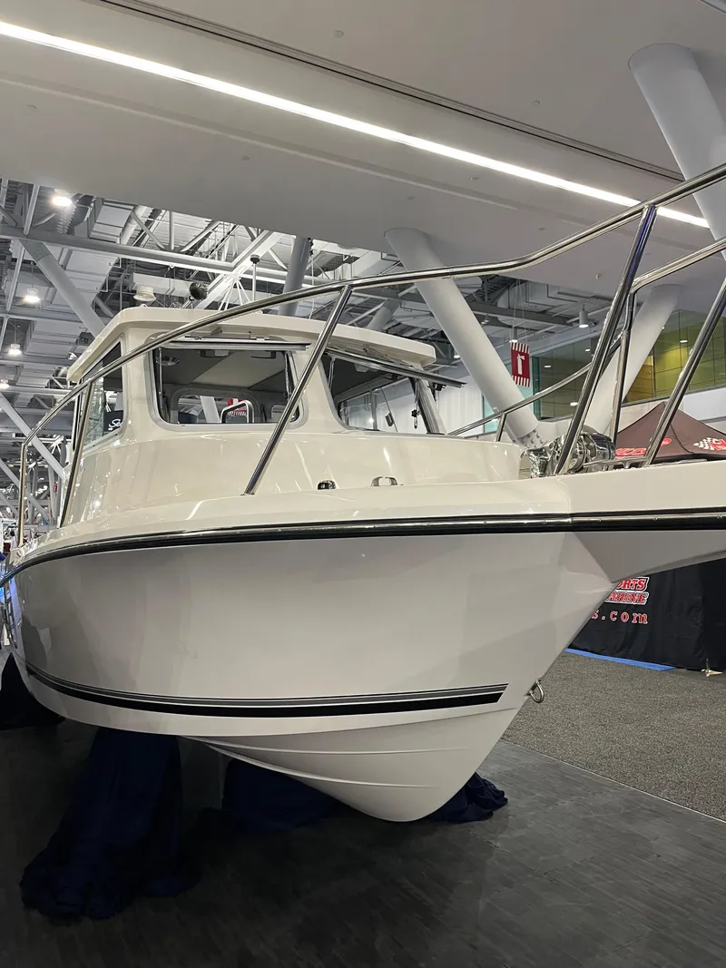 Slide: The Image of 2025 Defiance Admiral 220 EX boat displayed indoors at a show. - 2