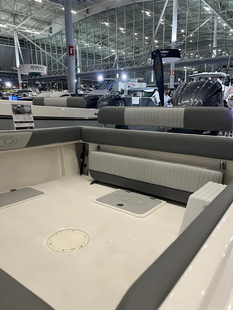 Slide: The Image of 2025 Defiance Admiral 220 EX boat interior at a showroom, featuring seating and storage. - 4