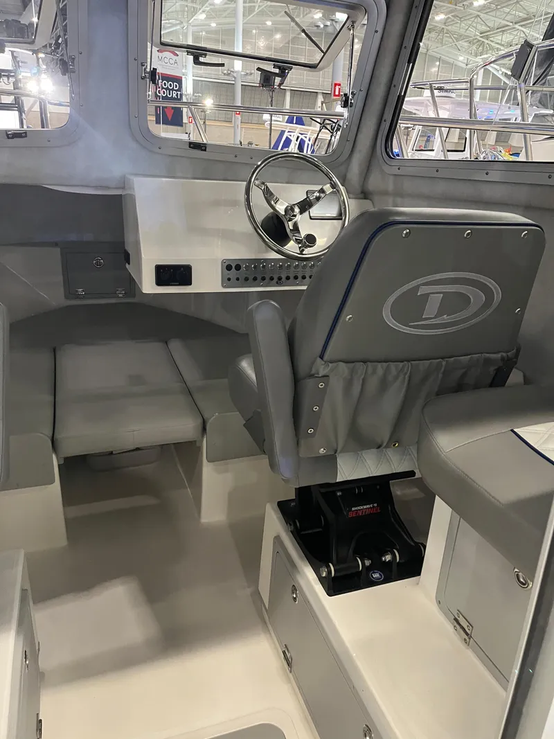 Slide: The Image of Interior of 2025 Defiance Admiral 220 EX boat, featuring steering wheel and seating. - 5