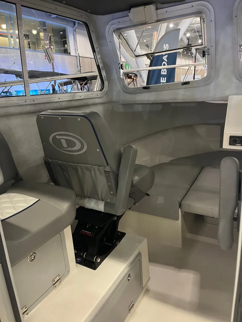 Slide: The Image of Interior of 2025 Defiance Admiral 220 EX boat, featuring seating and windows. - 6