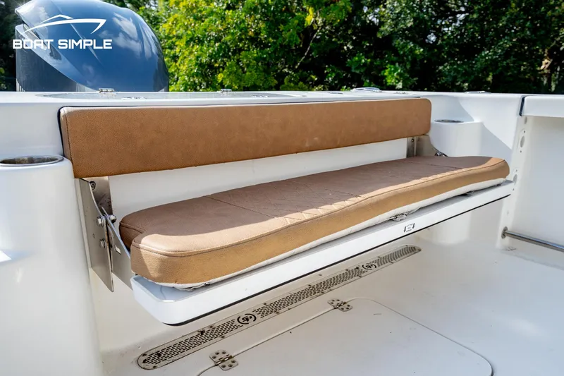 Slide: The Image of 2024 Sea Pro 239 Deep V CC boat with tan cushioned seating, outdoor setting. - 12