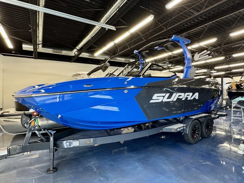 Slide: The Image of 2025 Supra SA 450 boat in showroom, vibrant blue and black design. - 4