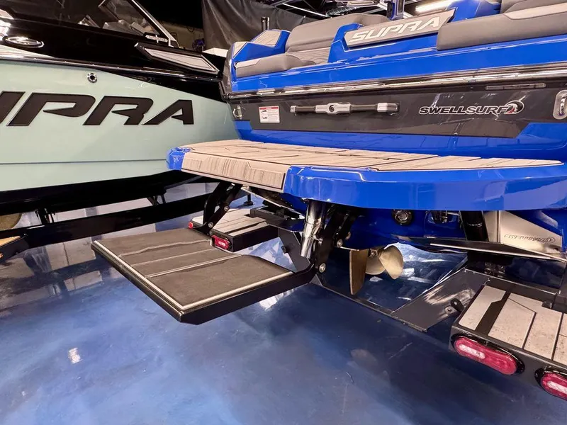 Slide: The Image of 2025 Supra SA 450 boat with SwellSurf system, blue and black design, rear view. - 5